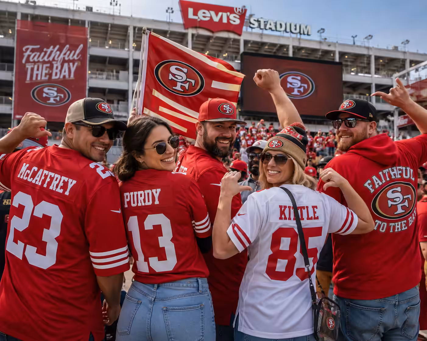 San Francisco 49ers fans cheering in red and gold jerseys while holding Christian McCaffrey, Brock Purdy, and George Kittle merchandise including trading cards and a bobblehead in front of Levi's Stadium.